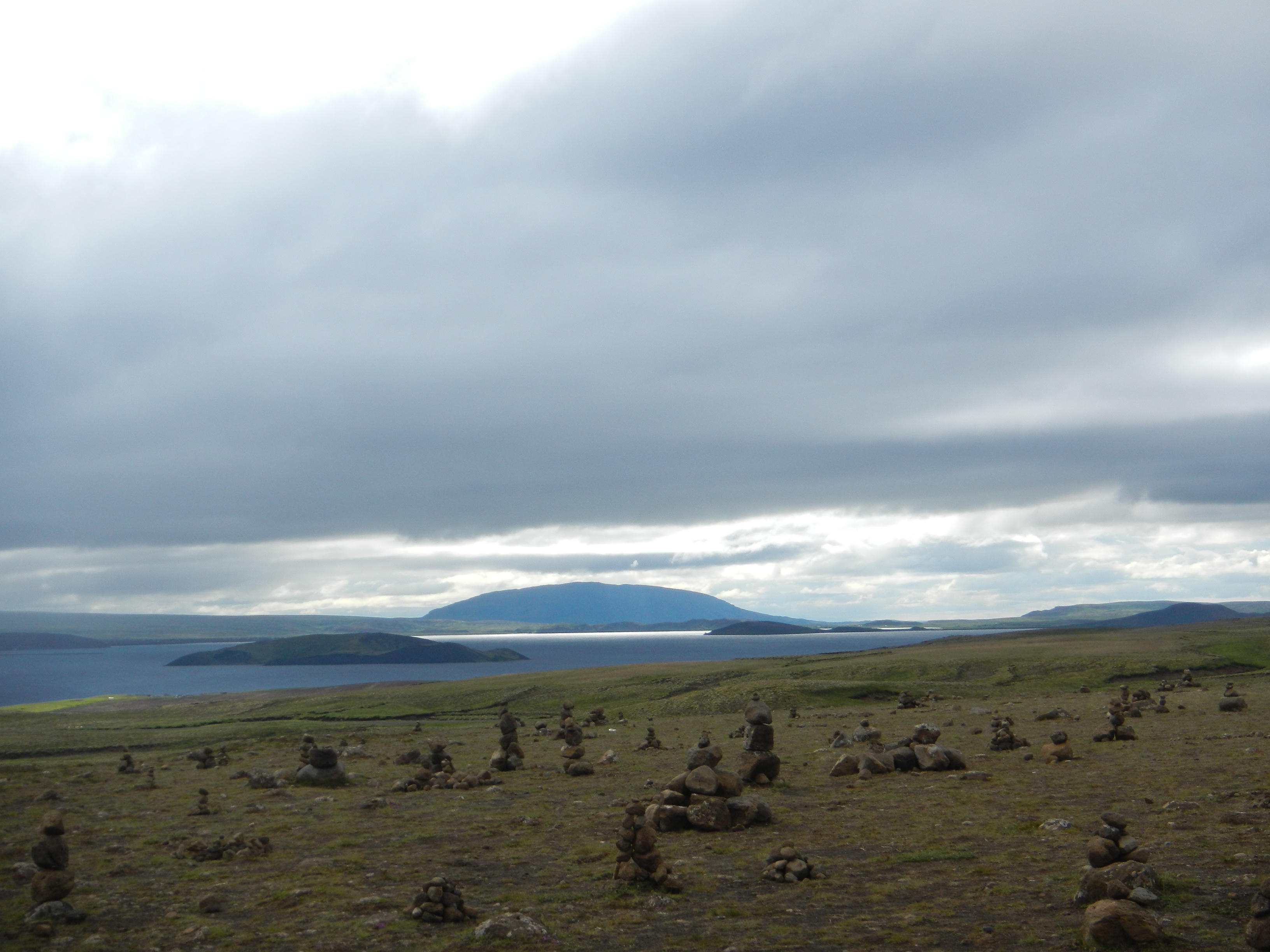 a field of rocks and a distant lake in iceland