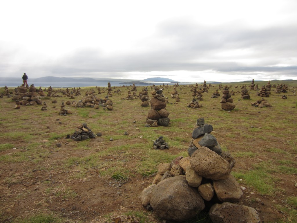 a field in iceland with piles of stacked rocks