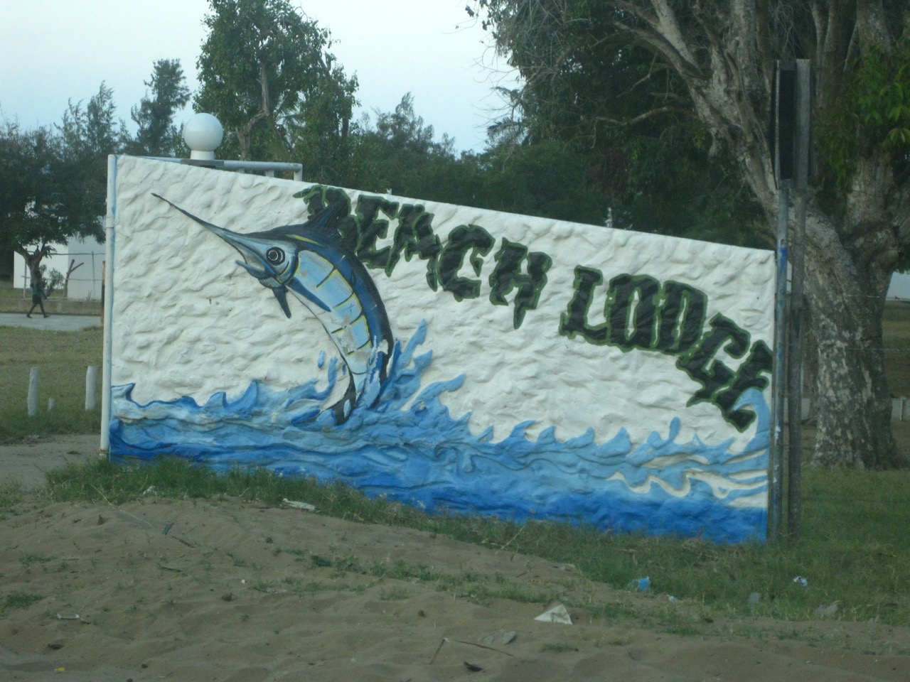 a jumping marlin on a beach lodge signpost in inhassoro